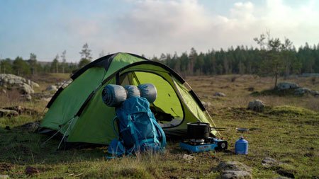 Muestra una imagen con una tienda de campaña y su equipamiento de camping